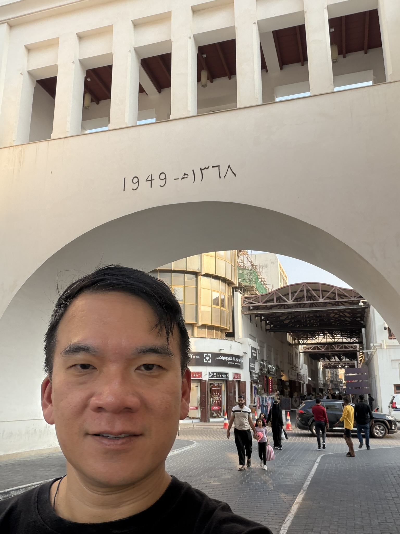 Standing beneath the arched 1949 gateway into Manama Souk