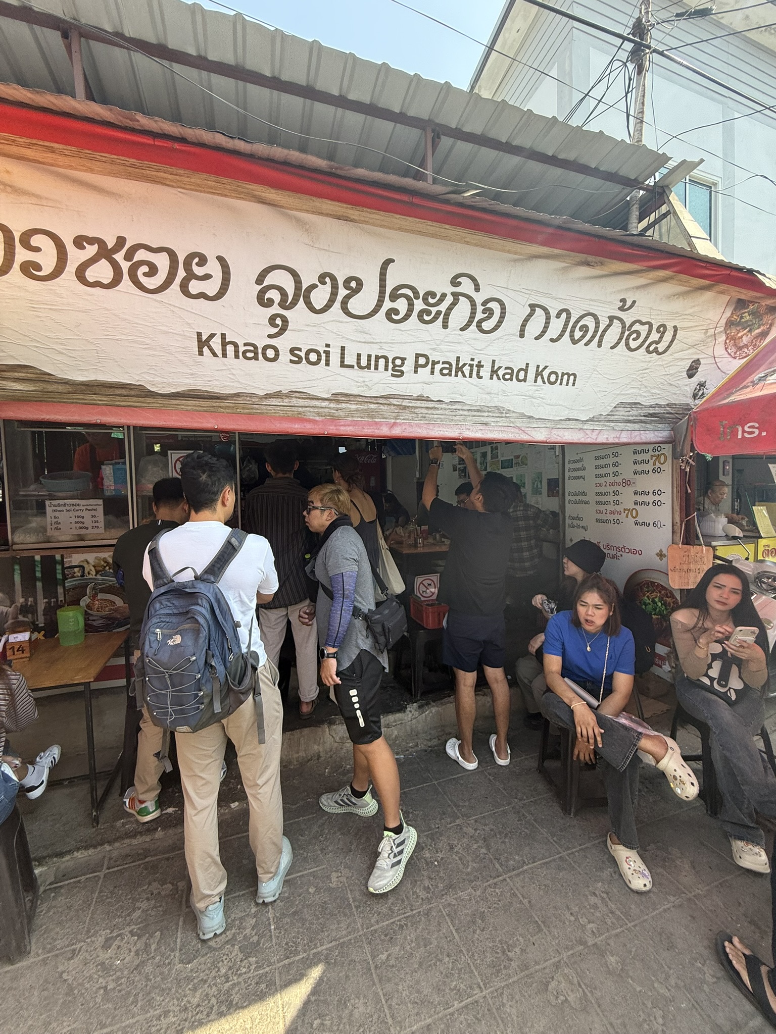 The famous Khao Soi Lung Prakit Kad Kom storefront with customers