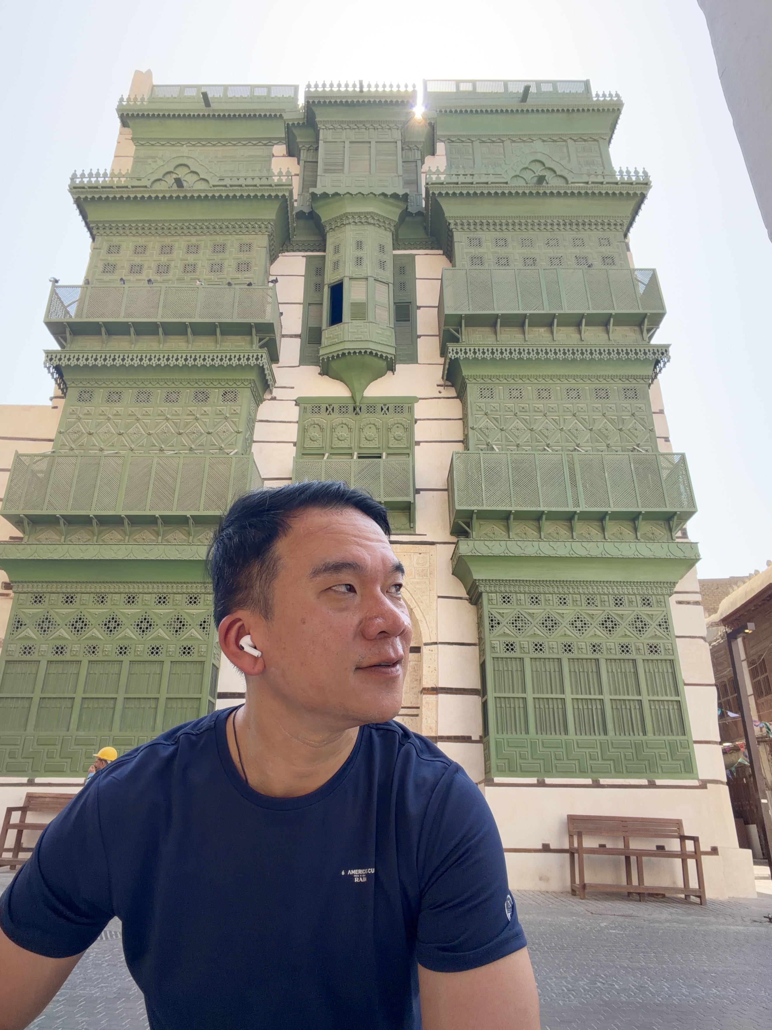 In front of a traditional Al Balad building with green wooden balconies