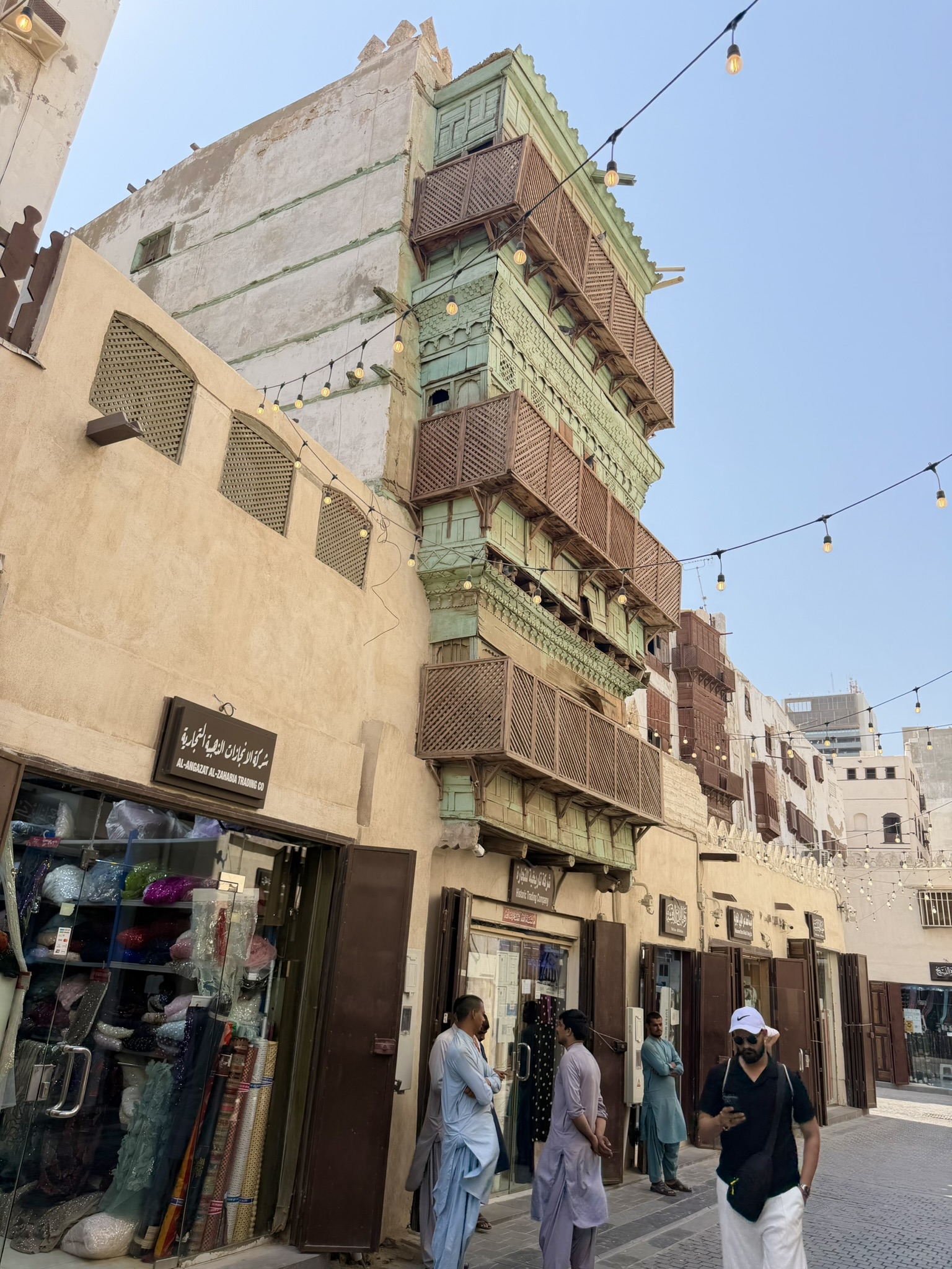 Traditional building with green and brown wooden balconies and string lights