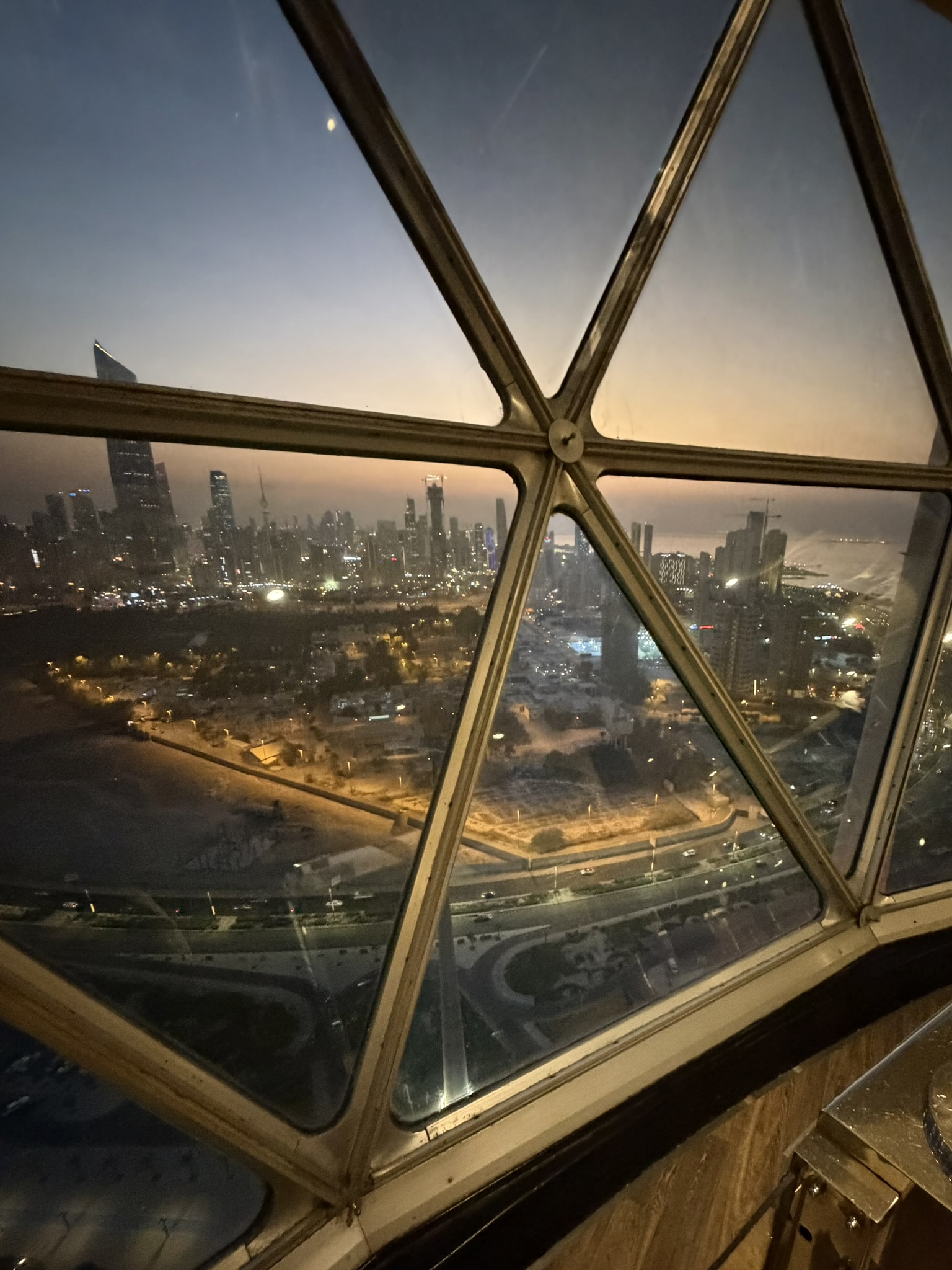 Golden dusk skyline seen through the Kuwait Towers windows