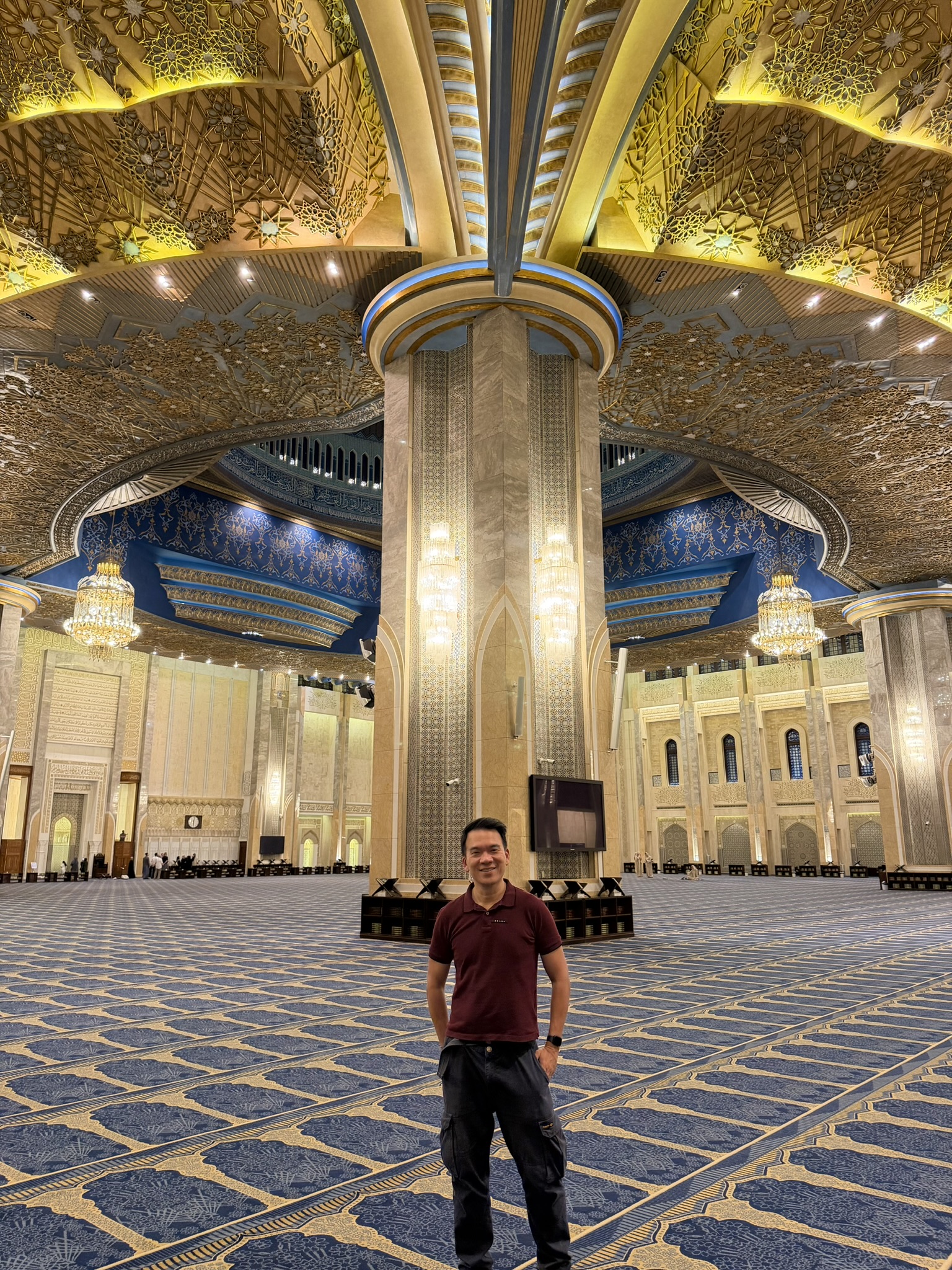 Inside the Grand Mosque of Kuwait with its ornate gold ceiling and chandeliers
