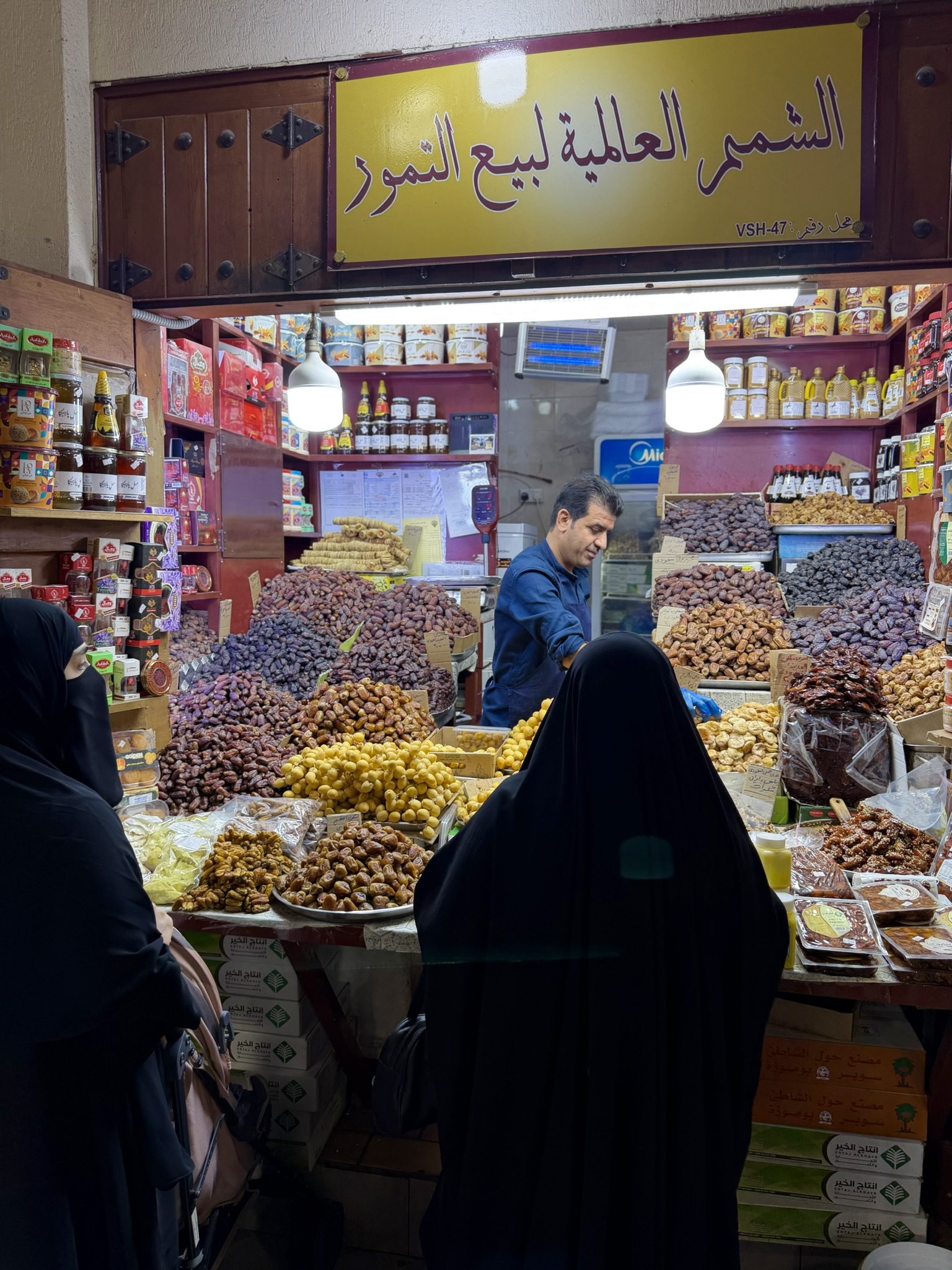 Dates and spices stall with a vendor at Souq Al-Mubarakiya