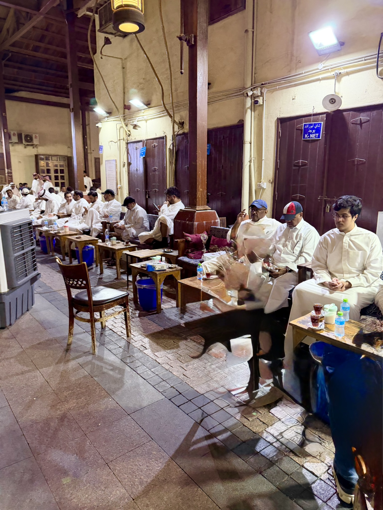 Traditional souq cafe with men in white dishdashas gathered over tea