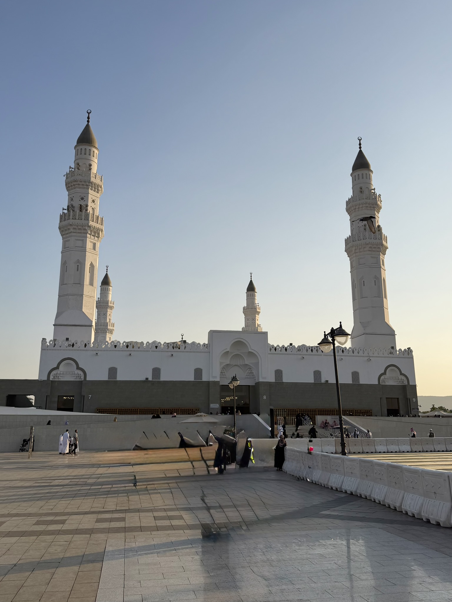 Quba Mosque exterior with white minarets at sunset