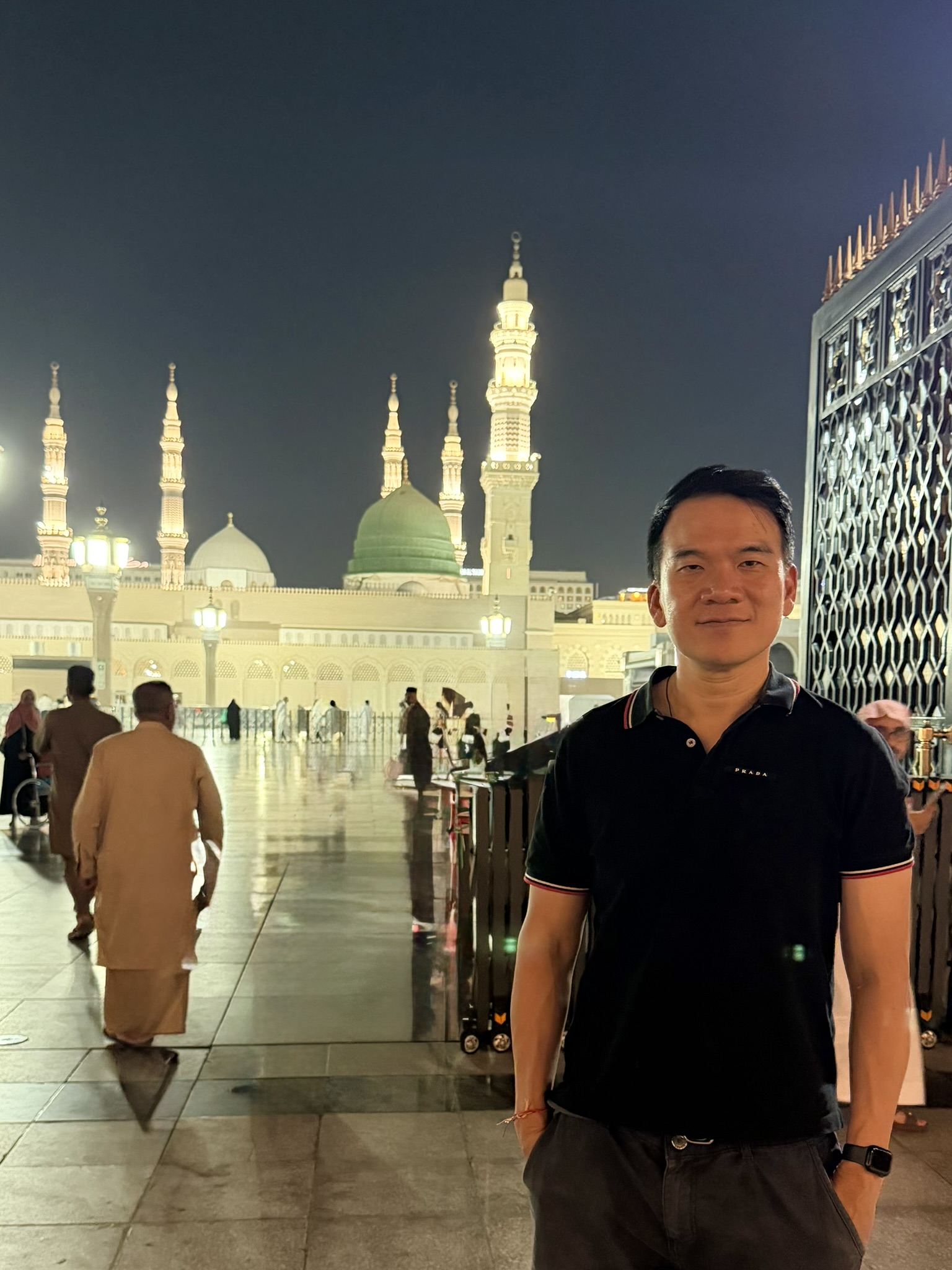 Standing before the Prophet's Mosque at night with the green dome