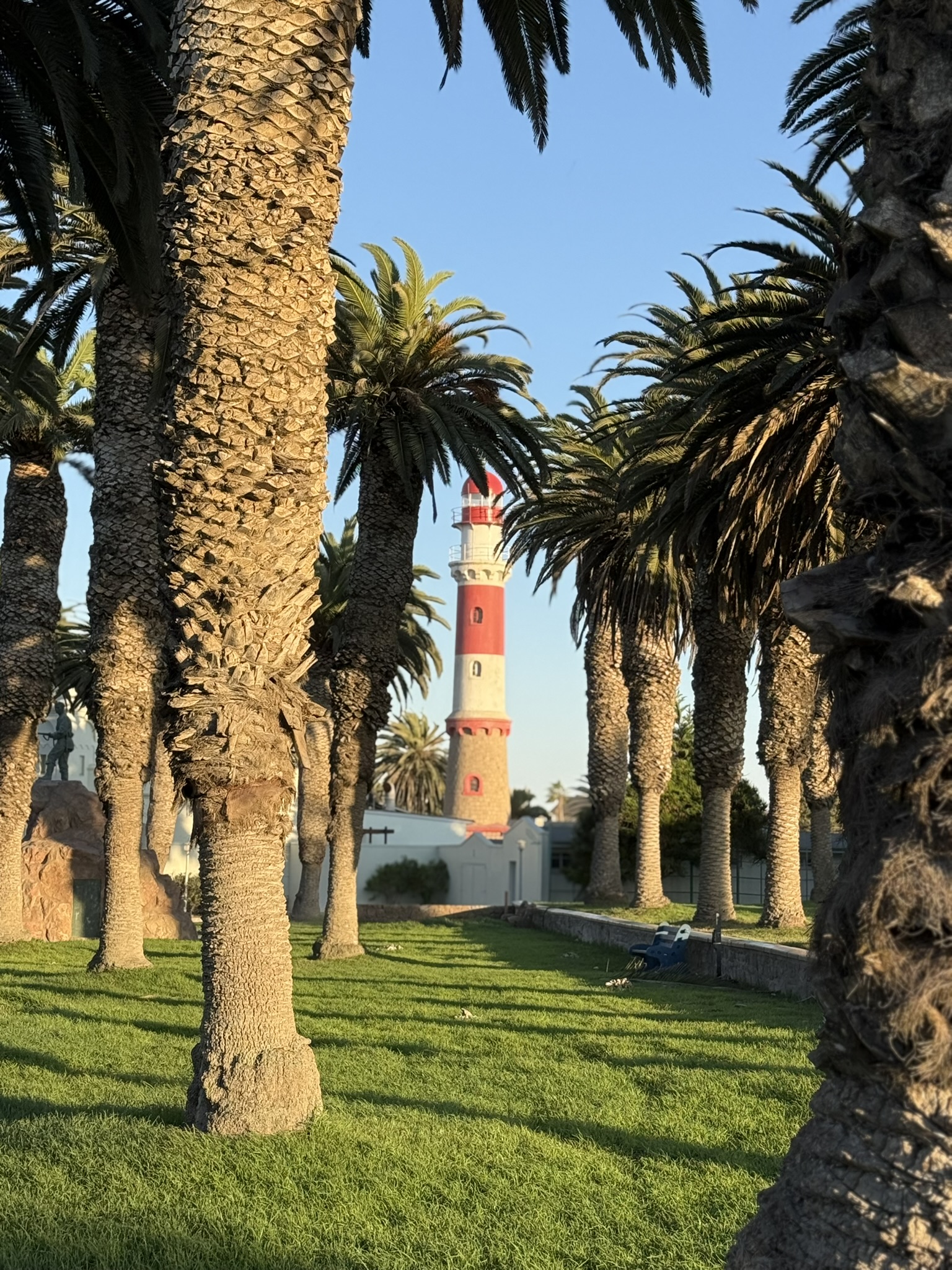 Swakopmund lighthouse through palm trees