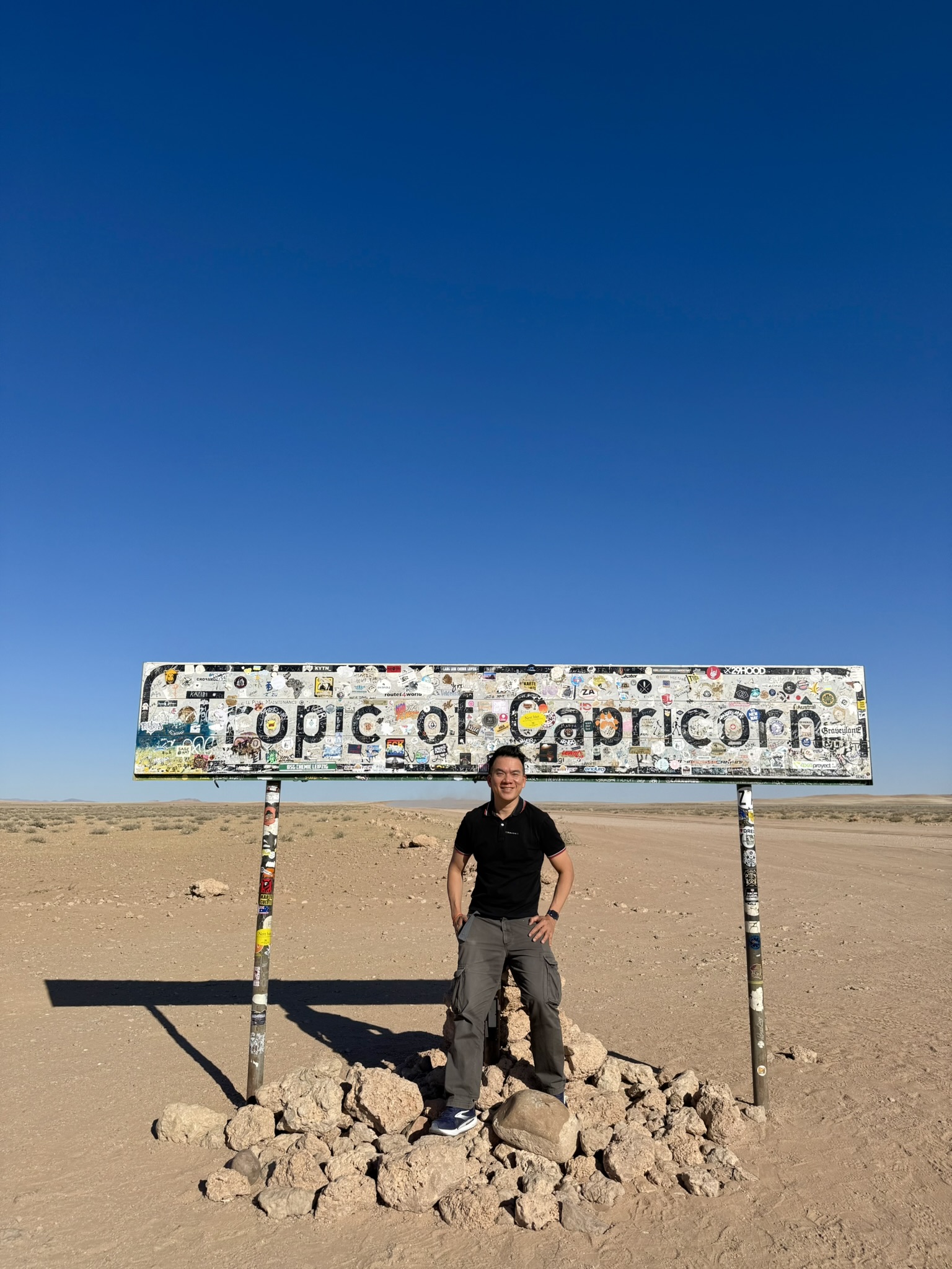 Standing under the Tropic of Capricorn sign in the Namib Desert