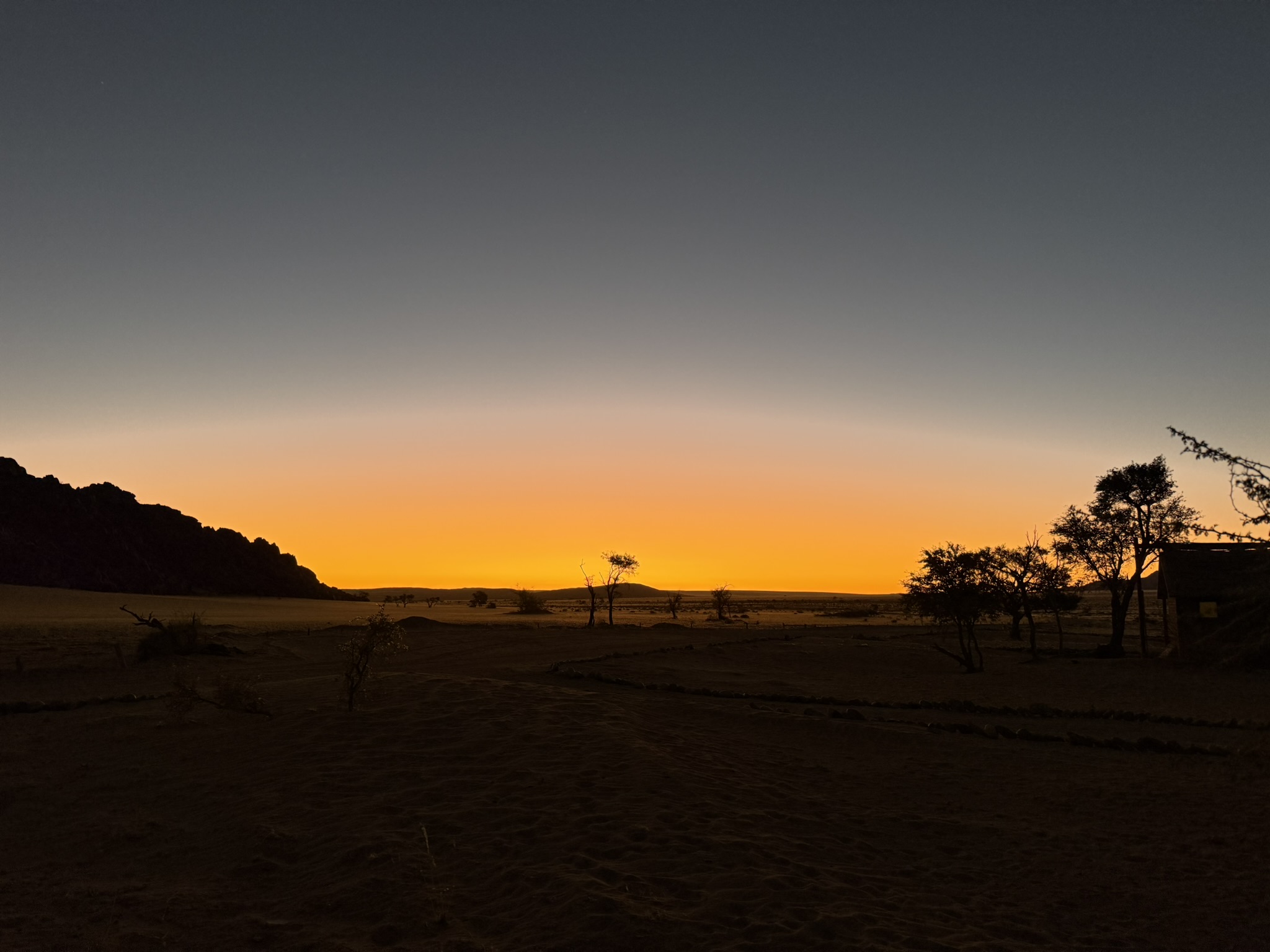 Golden sunset silhouette of Namibian desert landscape