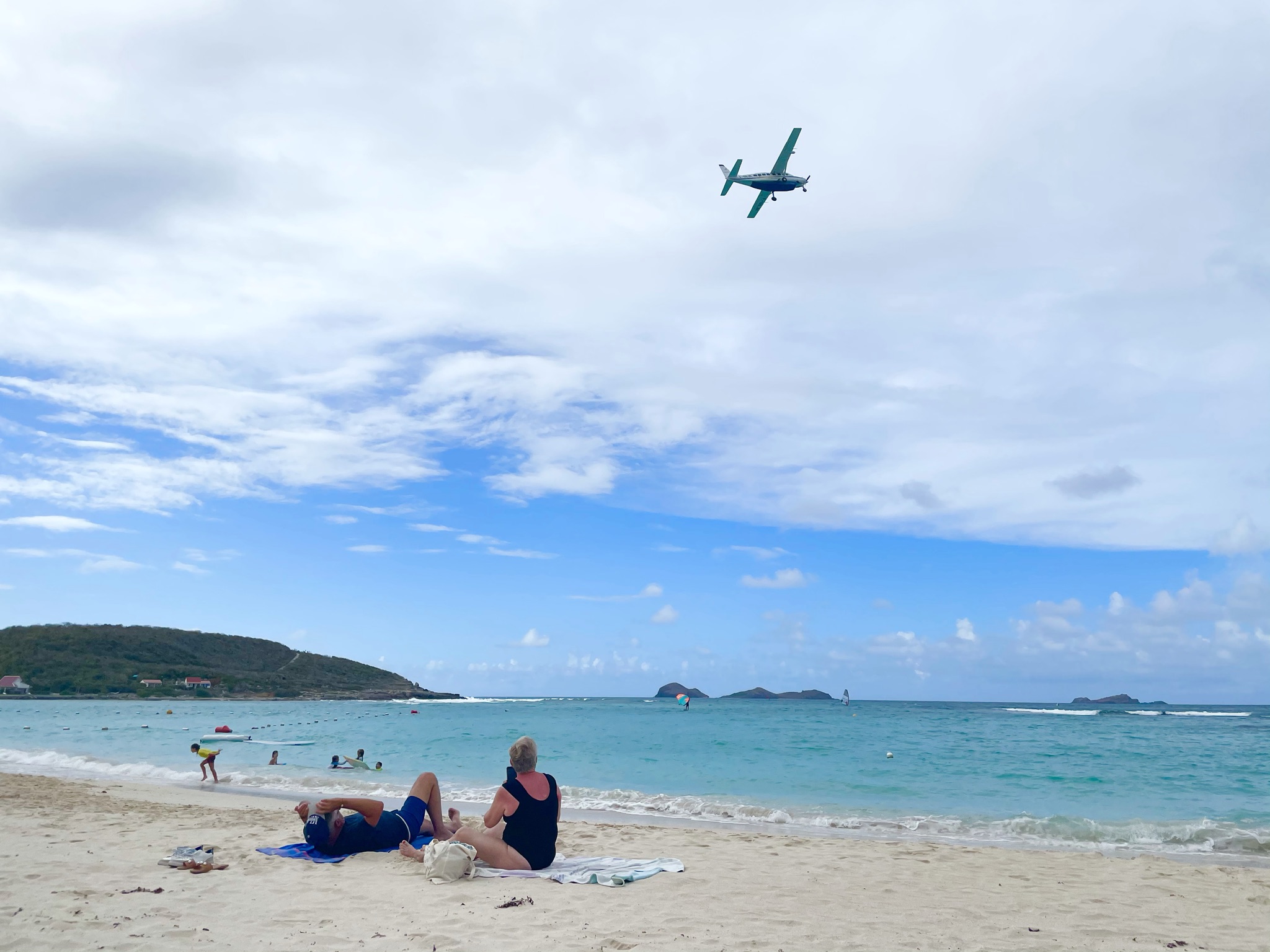 Beach scene with plane flying overhead