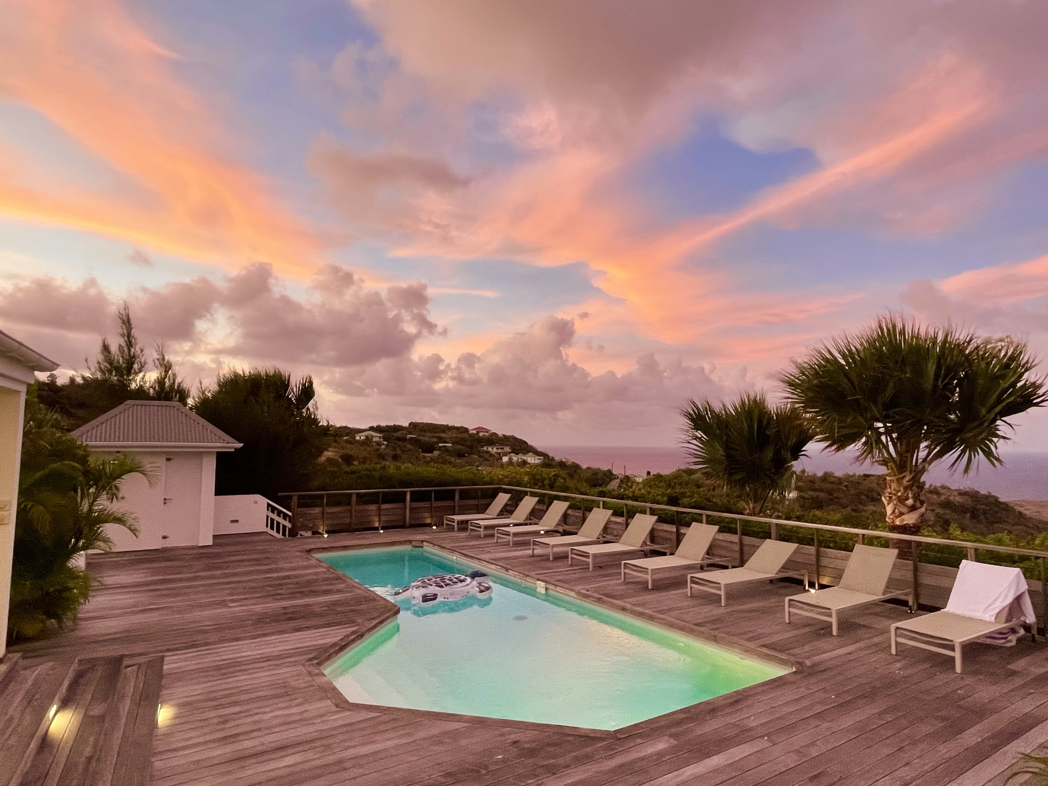 Villa pool deck at sunset with pink sky